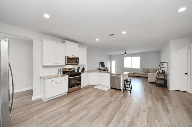 a kitchen with white cabinets and stainless steel appliances
