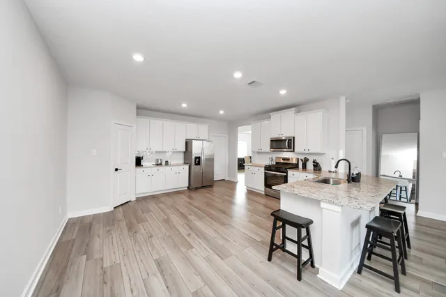 a open kitchen with white cabinets and stainless steel appliances