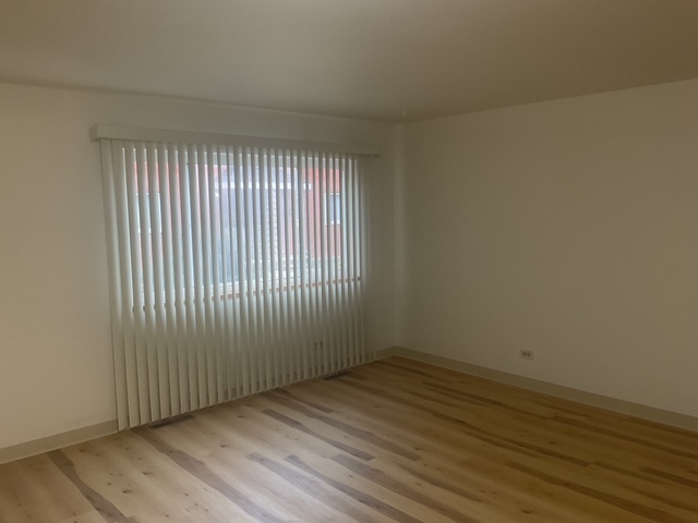 2223 171st Street Hazel Crest, IL 60429 - Photo 2 of 12 an empty room with wooden floor and windows