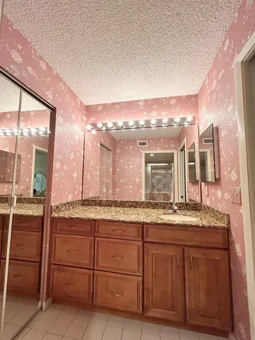 a bathroom with a granite countertop sink and a mirror