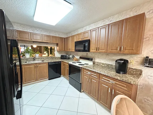 a kitchen with stainless steel appliances granite countertop a stove sink and cabinets