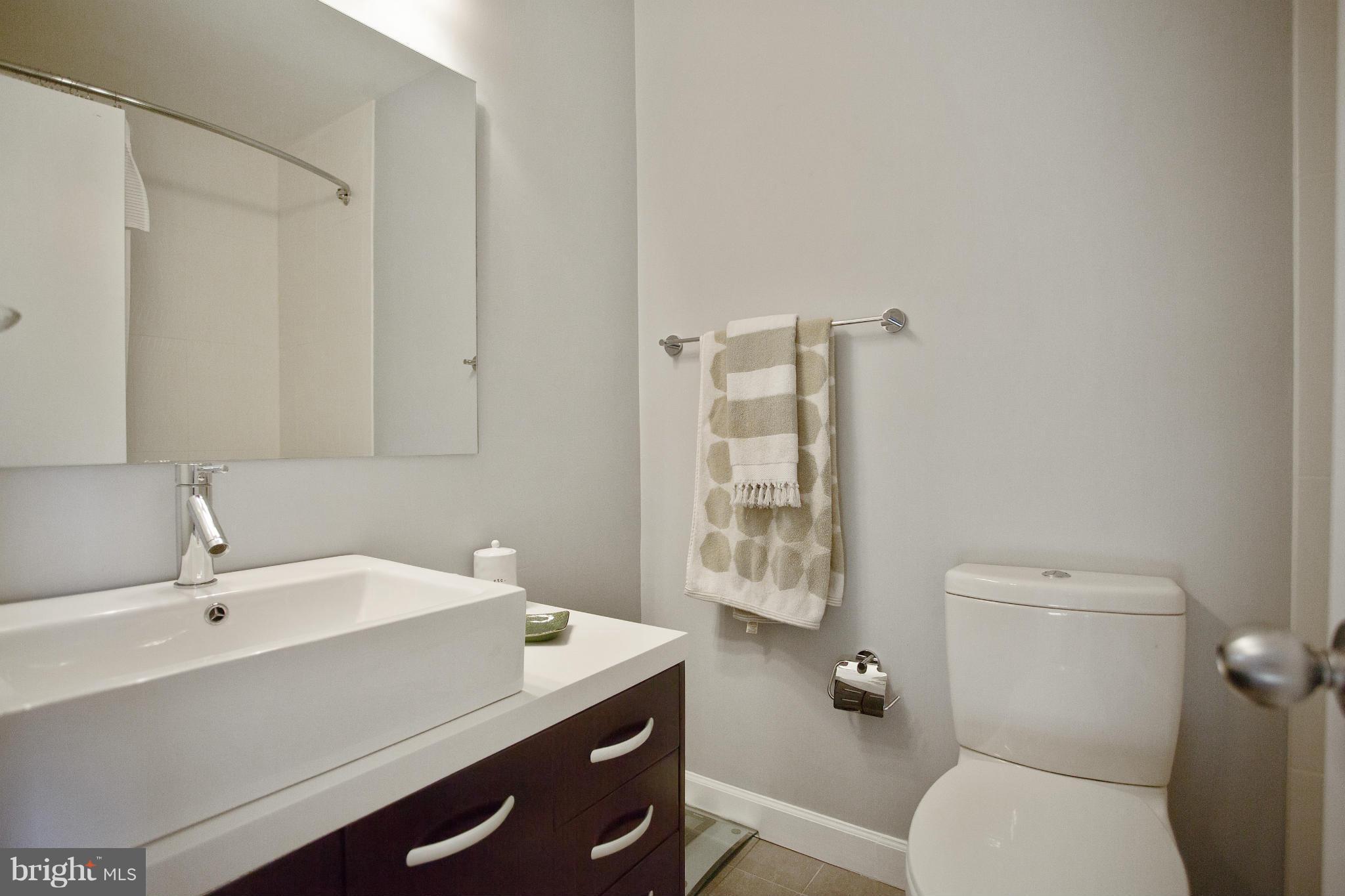 2040 Lakebreeze Way Reston, VA 20191 - Photo 22 of 29 a bathroom with a granite countertop sink a toilet and a mirror