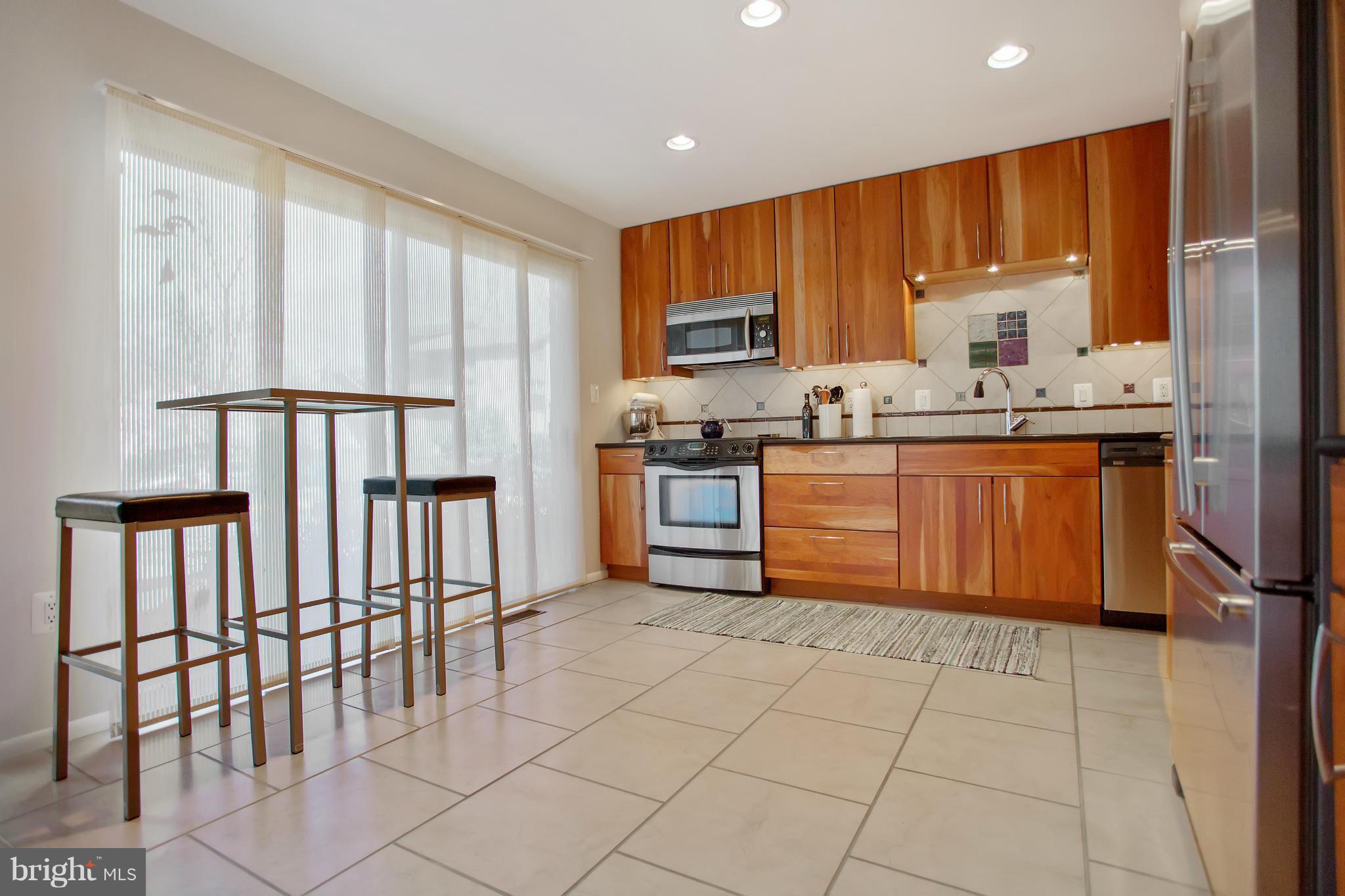 2040 Lakebreeze Way Reston, VA 20191 - Photo 6 of 29 a kitchen with stainless steel appliances granite countertop a stove top oven a sink dishwasher and a refrigerator