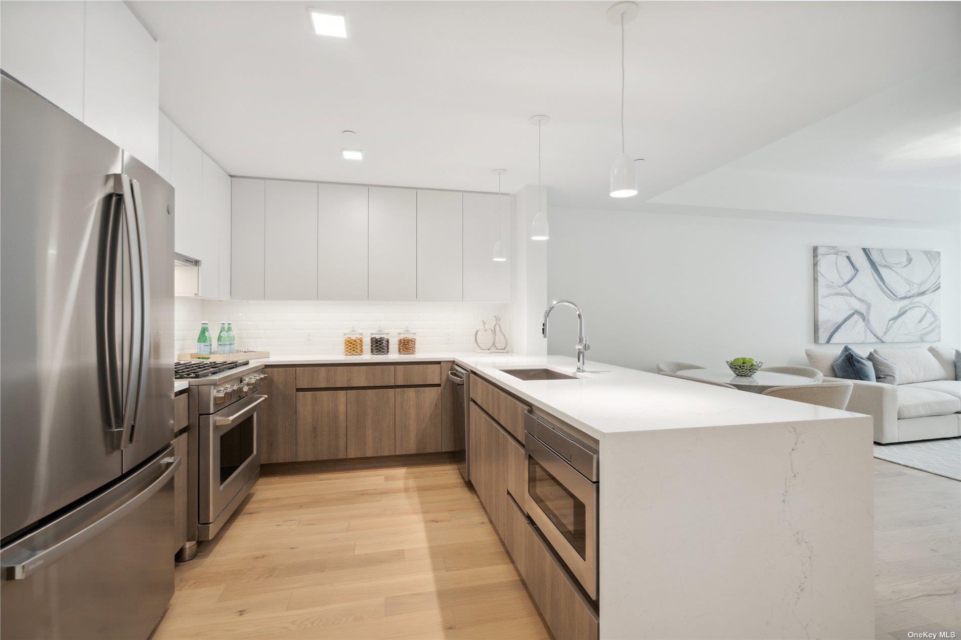 218 Middle Neck Road, Unit 110 Great Neck, NY 11021 - Photo 16 of 19 a kitchen with stainless steel appliances granite countertop a sink and a refrigerator