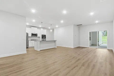 a view of kitchen with kitchen island wooden floor center island and stainless steel appliances