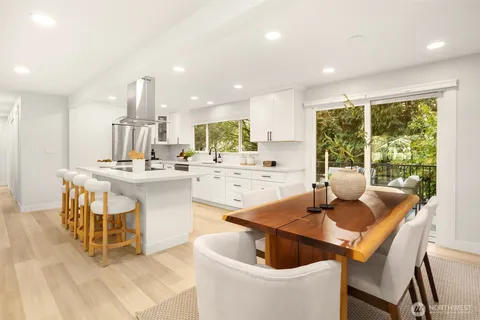a kitchen with a dining table chairs and white appliances