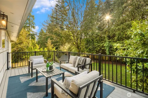 a roof deck with table and chairs and wooden floor