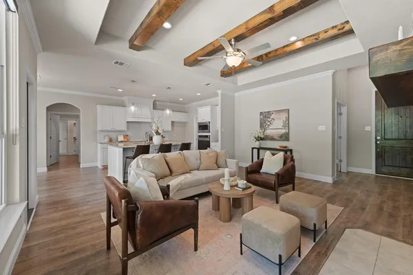 a living room with furniture and a view of kitchen