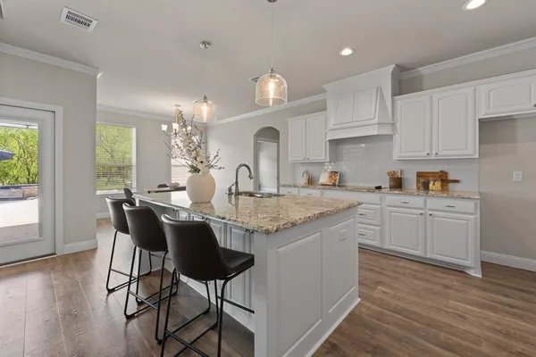 a kitchen with granite countertop white cabinets and window