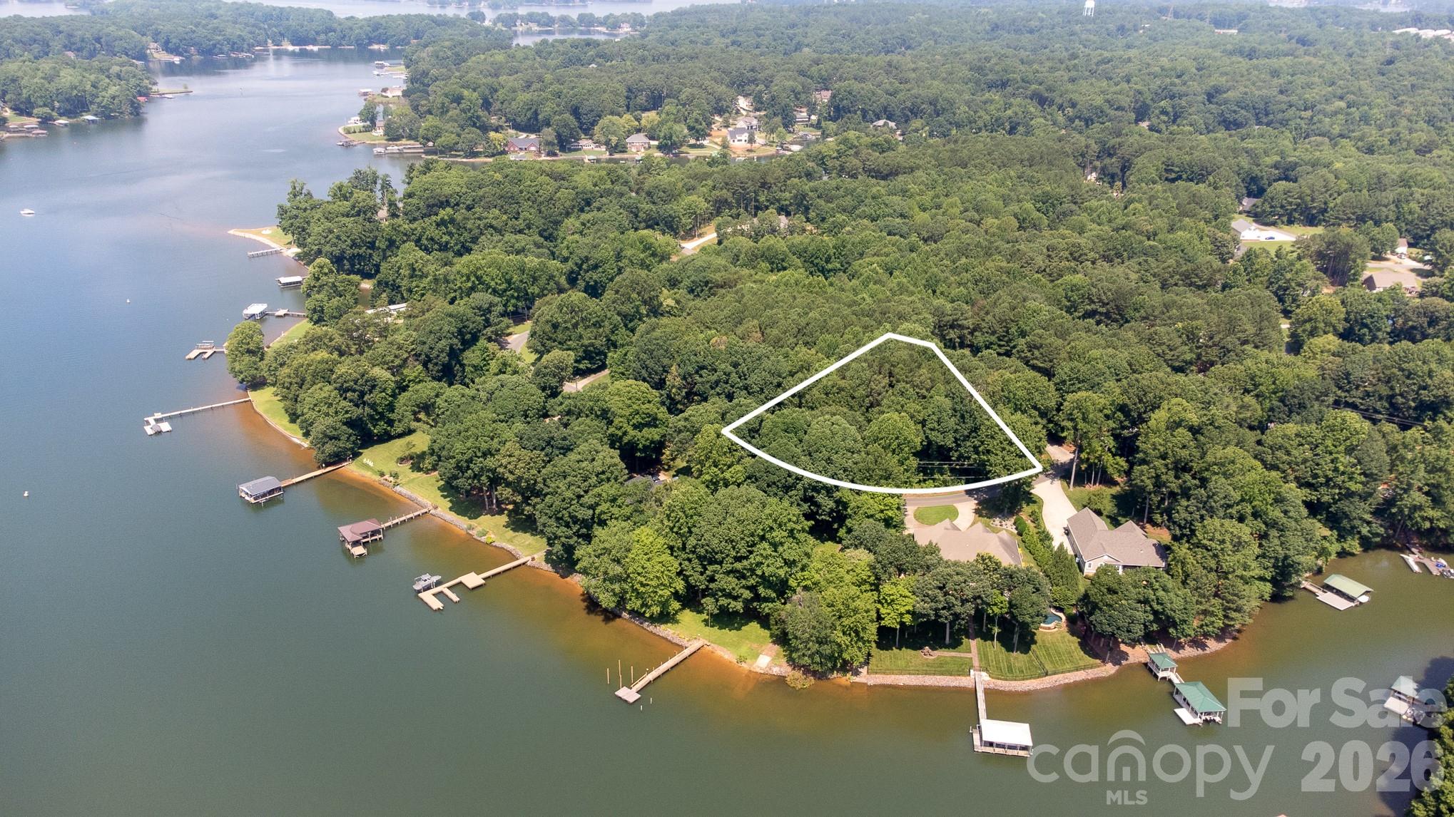 an aerial view of a house with a yard and lake view