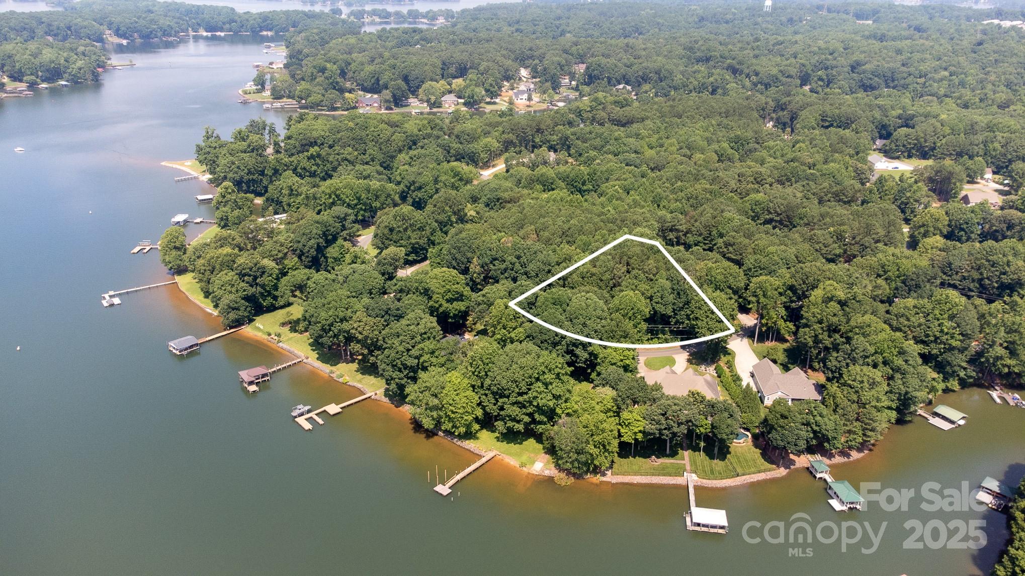 an aerial view of a house with a yard and lake view
