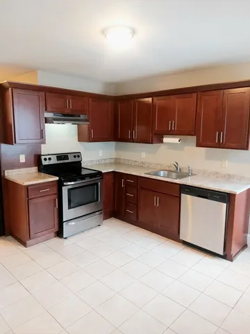a kitchen with granite countertop a stove a sink and a microwave