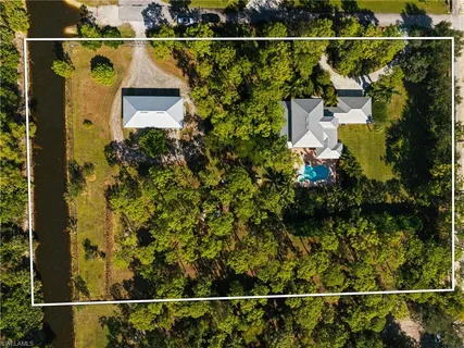a front view of a house with a yard and swimming pool