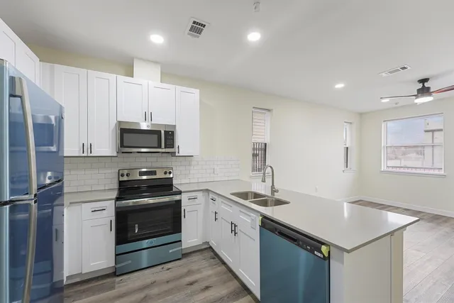 a kitchen with white cabinets stainless steel appliances and sink