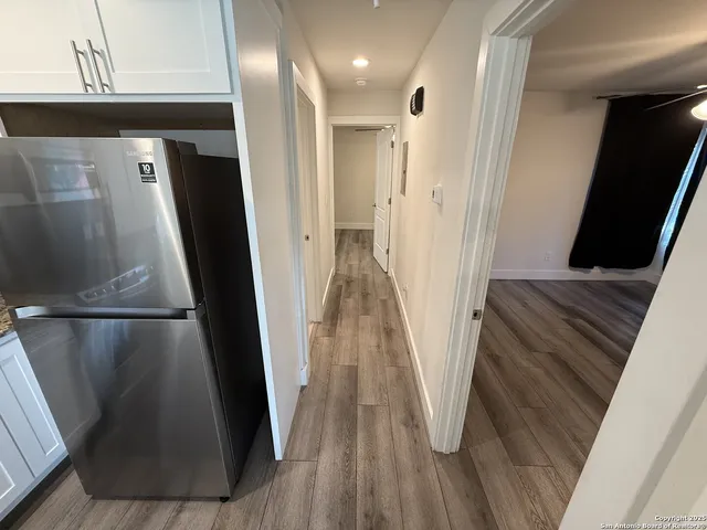 a view of a hallway with wooden floor and staircase