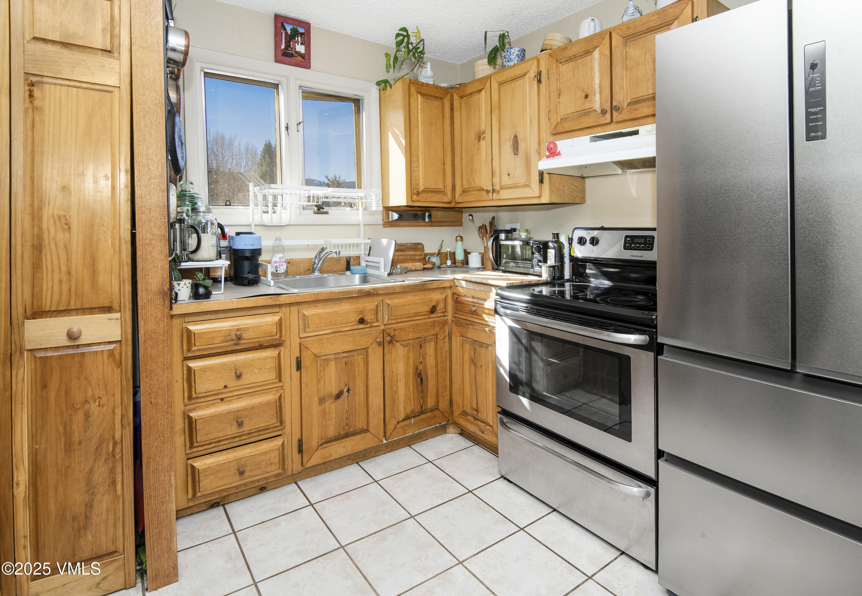 2448 Garmisch Drive, Unit 4 Vail, CO 81657 - Photo 7 of 19 a kitchen with stainless steel appliances a stove a sink and a refrigerator