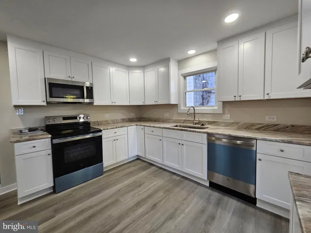 a kitchen with stainless steel appliances a refrigerator sink and microwave