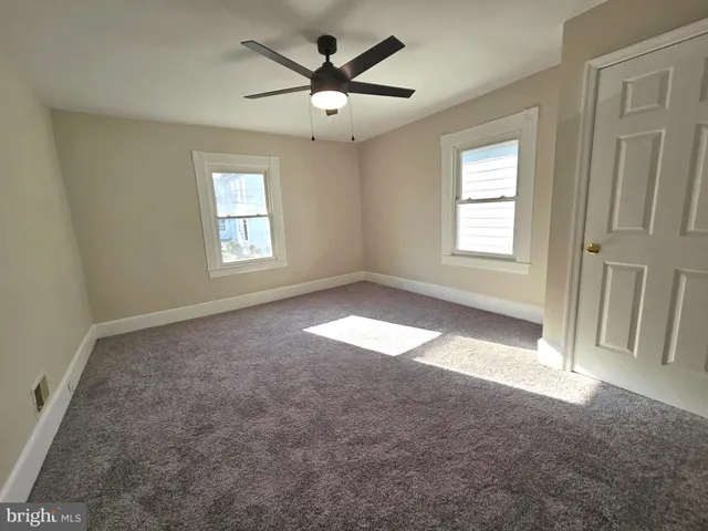 an empty room with fan and windows
