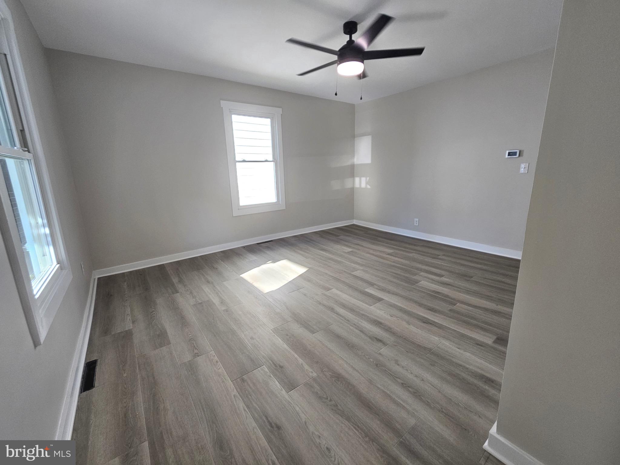 161 East Main Street Orange, VA 22960 - Photo 7 of 19 an empty room with wooden floor fan and windows