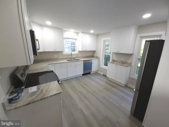 a kitchen with granite countertop wooden cabinets and black stainless steel appliances