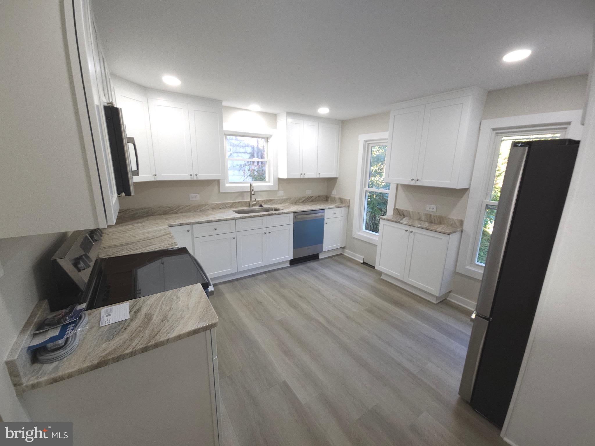161 East Main Street Orange, VA 22960 - Photo 10 of 19 a kitchen with a sink dishwasher a refrigerator and wooden floor