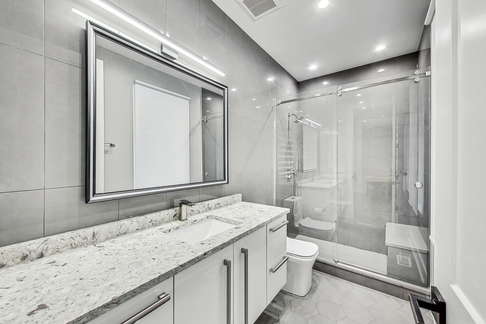 1331 Pfingsten Road Northbrook, IL 60062 - Photo 26 of 38 a bathroom with a granite countertop sink a toilet and shower