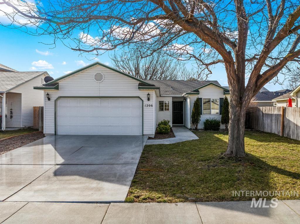 Ranch-style house featuring concrete driveway and an attached garage
