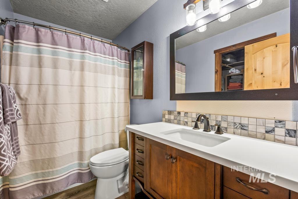 1206 Flint Drive Caldwell, ID 83607 - Photo 11 of 20 Bathroom with vanity, a shower with shower curtain, a textured ceiling, and a textured wall