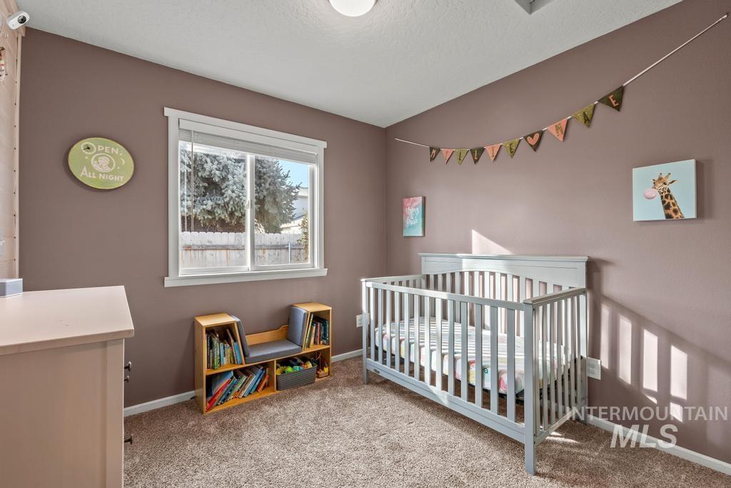 1206 Flint Drive Caldwell, ID 83607 - Photo 12 of 20 Bedroom featuring a nursery area, light carpet, and a textured ceiling