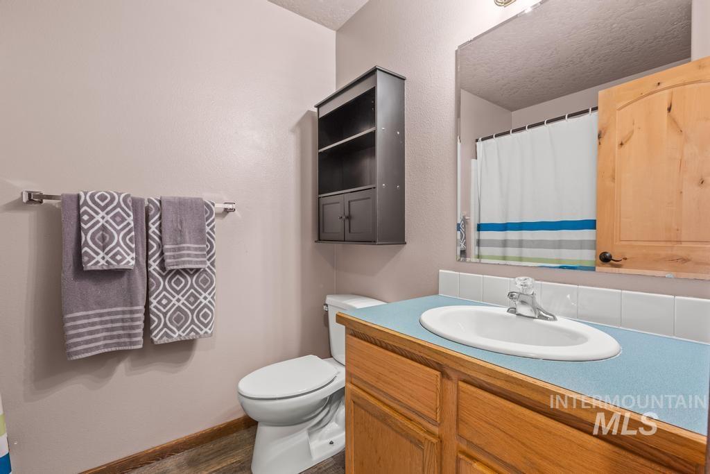 1206 Flint Drive Caldwell, ID 83607 - Photo 13 of 20 Full bath featuring a shower with curtain, vanity, and dark wood-type flooring
