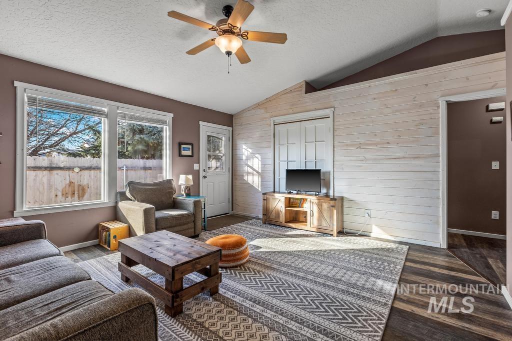 1206 Flint Drive Caldwell, ID 83607 - Photo 5 of 20 Living area with wooden walls, a ceiling fan, and dark wood-style flooring