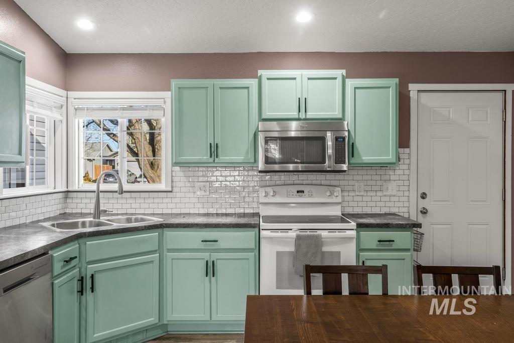 1206 Flint Drive Caldwell, ID 83607 - Photo 7 of 20 Kitchen featuring green cabinets, stainless steel appliances, dark countertops, a textured ceiling, and recessed lighting