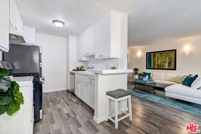 a kitchen with stainless steel appliances a stove a sink and white cabinets