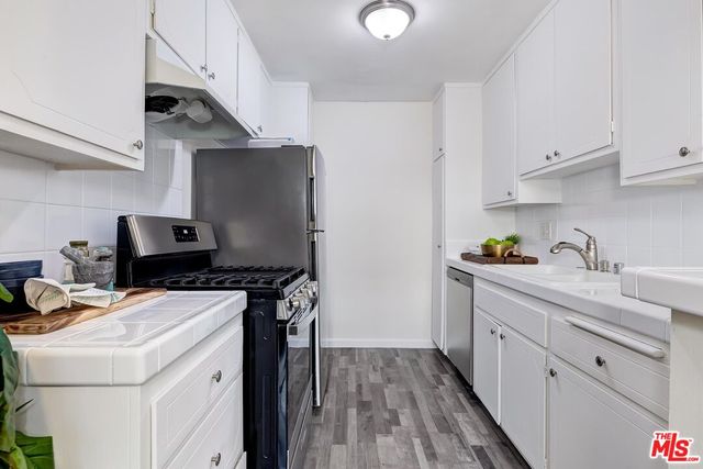 a kitchen with stainless steel appliances a sink a counter space and cabinets