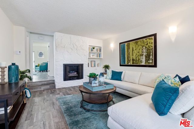 a living room with furniture a fireplace and a potted plant