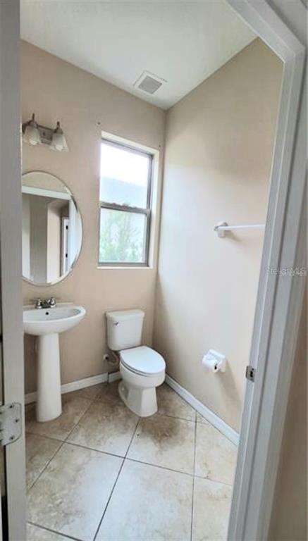 4025 Scarlet Branch Road Orlando, FL 32824 - Photo 11 of 13 a bathroom with a toilet sink and mirror