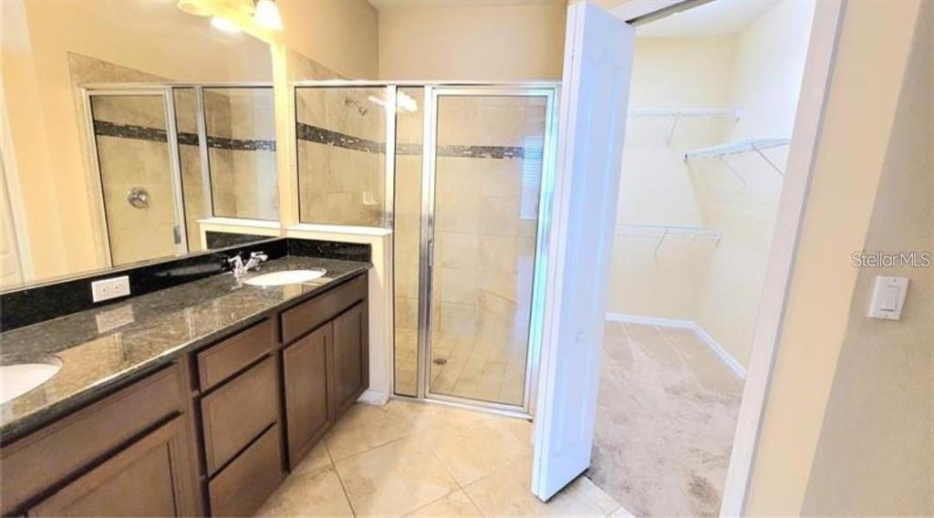 4025 Scarlet Branch Road Orlando, FL 32824 - Photo 7 of 13 a bathroom with a granite countertop sink and a mirror