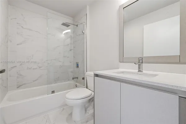 a bathroom with a shower sink mirror and toilet