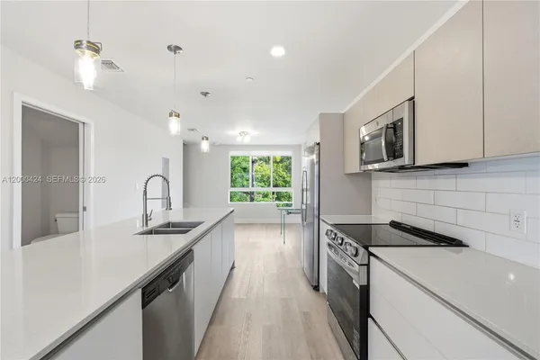 a kitchen with stainless steel appliances a sink stove and cabinets