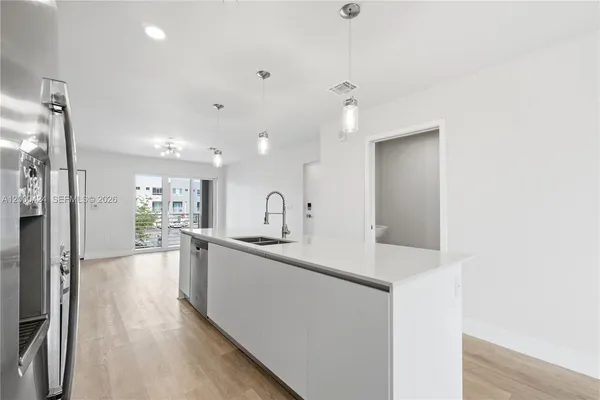 a view of a kitchen with a sink and a refrigerator