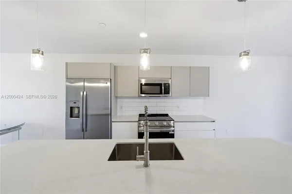 a kitchen with a refrigerator and a stove top oven