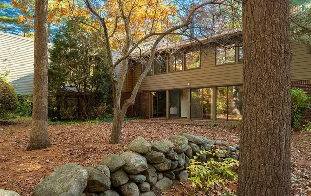 a front view of a house with a tree