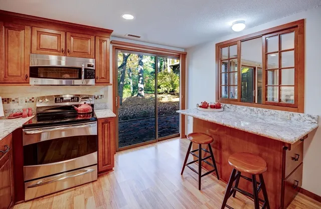 a kitchen with stainless steel appliances granite countertop wooden cabinets and stove top oven