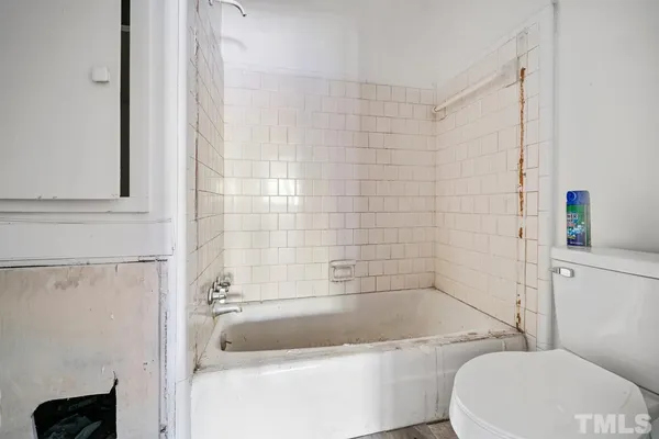 a bath room with a toilet and a bath tub