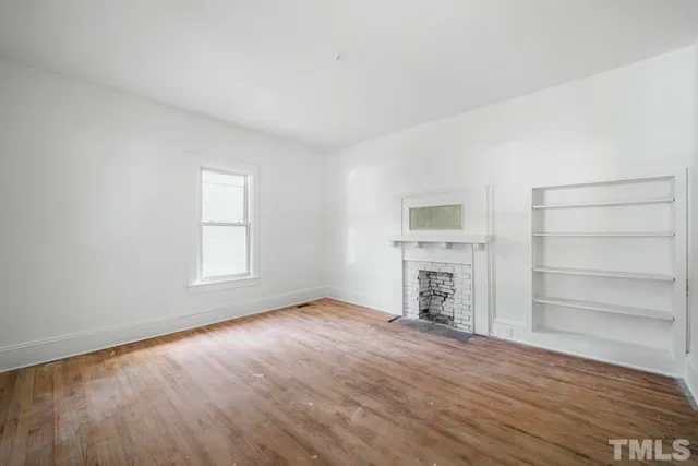 wooden floor fireplace and windows in an empty room