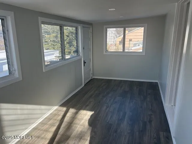 a view of an empty room and wooden floor and a window