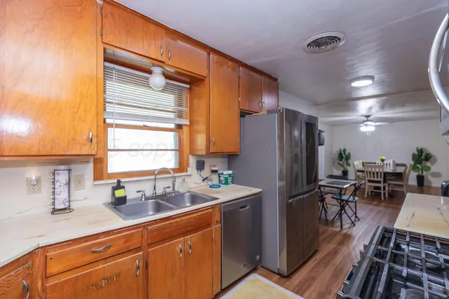 a kitchen with sink refrigerator dining table and chairs