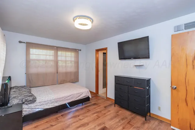 a bedroom with a bed and a flat screen television