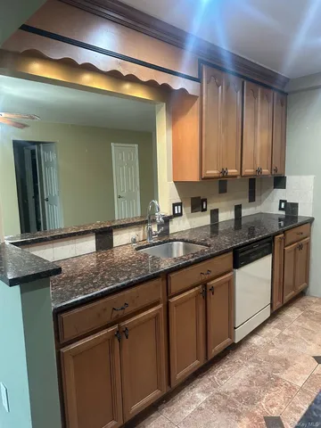 a bathroom with a granite countertop double sink and a large mirror