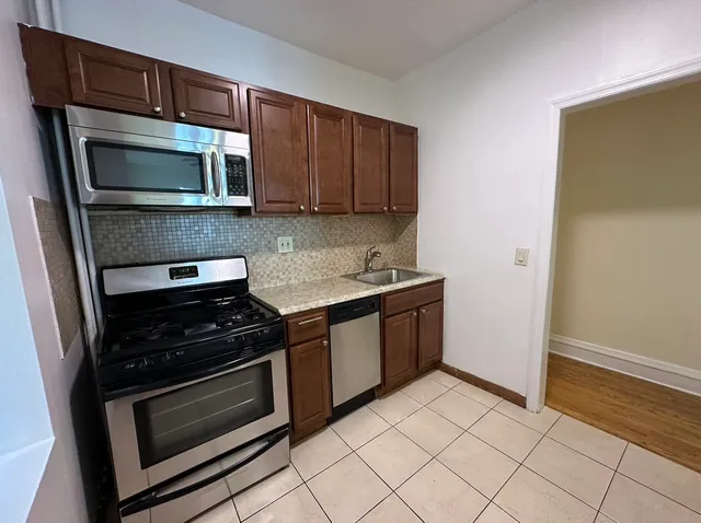 a kitchen with stainless steel appliances a stove a microwave and a sink